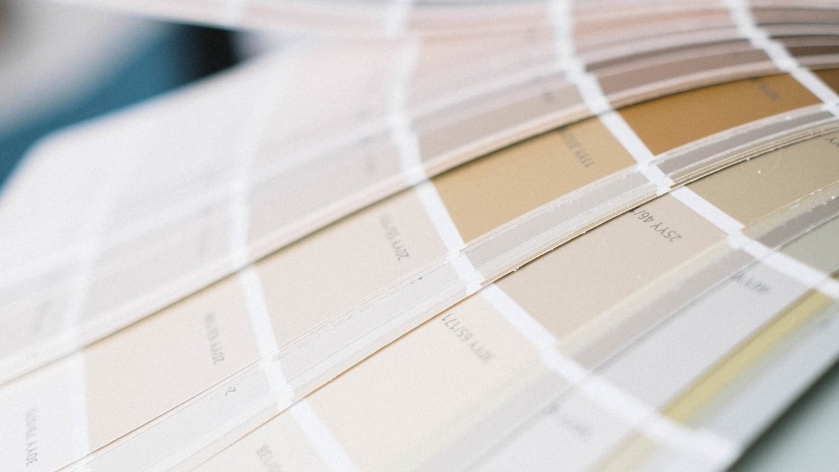 A fan of paint sample cards spread open, the stage where the sheen decision gets made